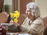 Representative Murphy sits at her desk in the House Chamber and arranges daffodils.